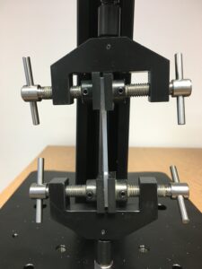 A tensile test sample being held between two clamps.